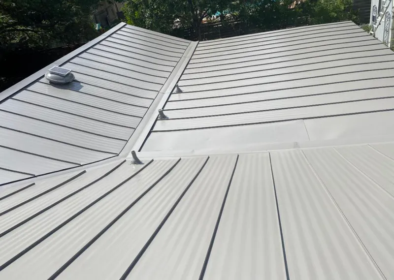 Solar attic fan installed on a metal roof for Roof Ventilation in Handy