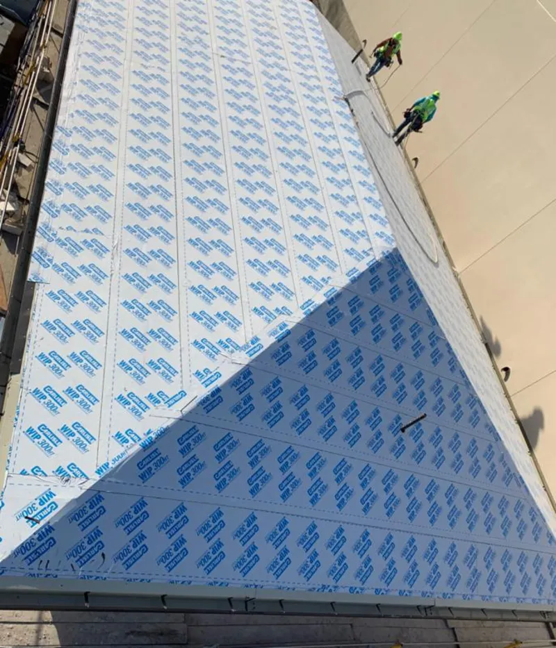 Professional roofers installing underlayment on a metal roof in Handy